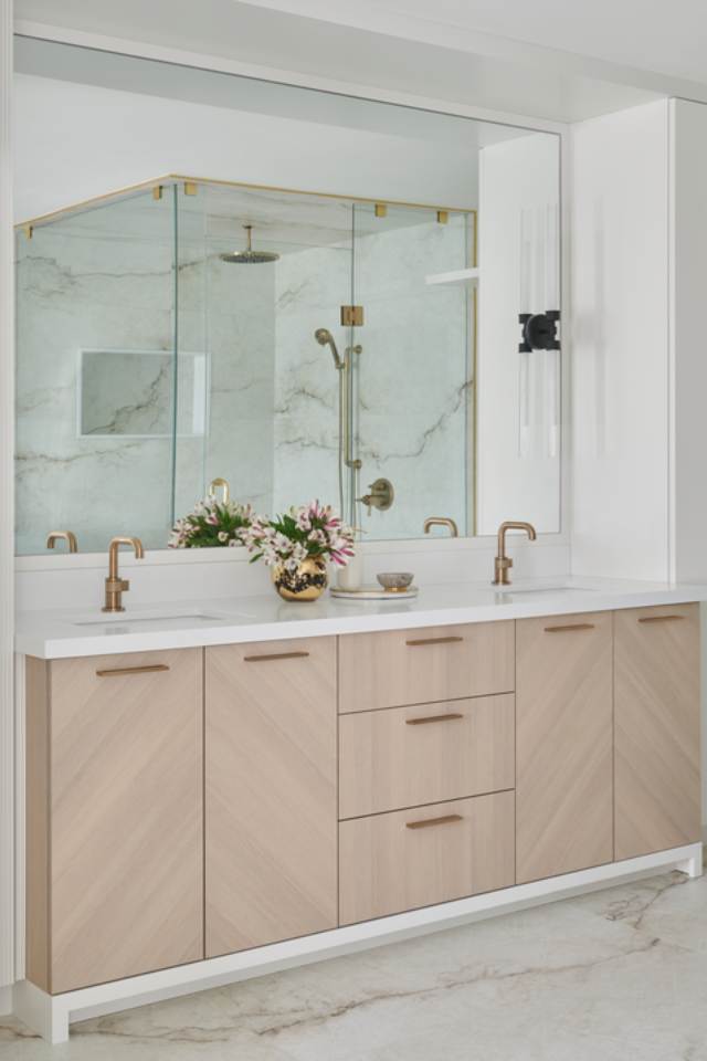 white and wood bathroom with marble tile flooring and gold accents